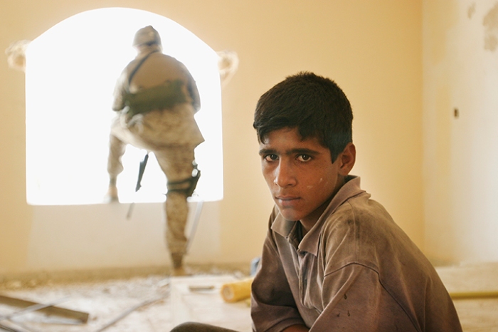 Boy on construction team building birthing center funded and then defunded  by U.S. Army. Marines promised to resume support — if local leaders cooperated with them. Jurf-al-Sakhar, Iraq, August 8, 2004